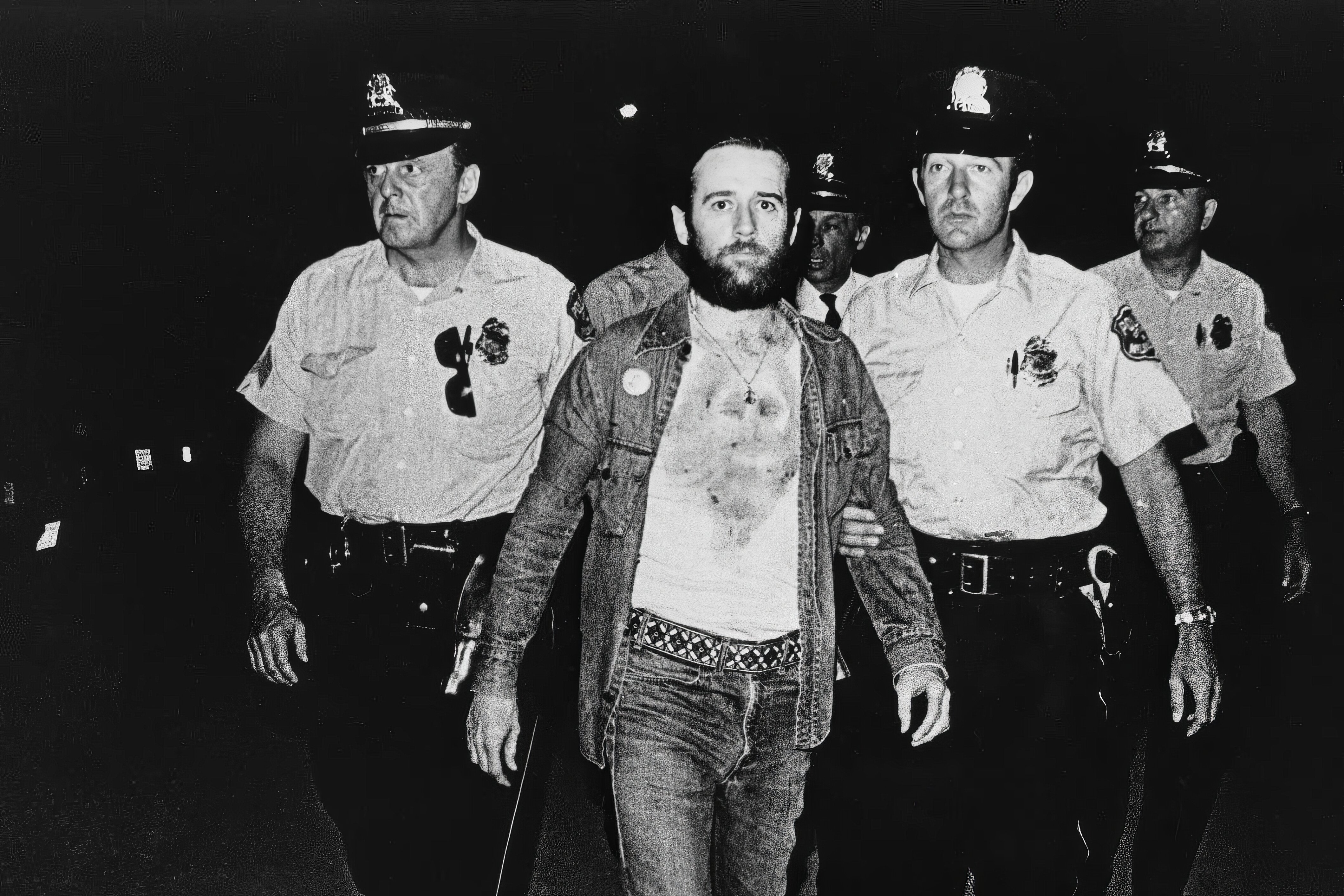 George Carlin being escorted by police